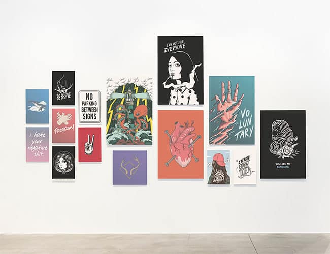 A minimalist white gallery wall adorned with various pieces of artwork.